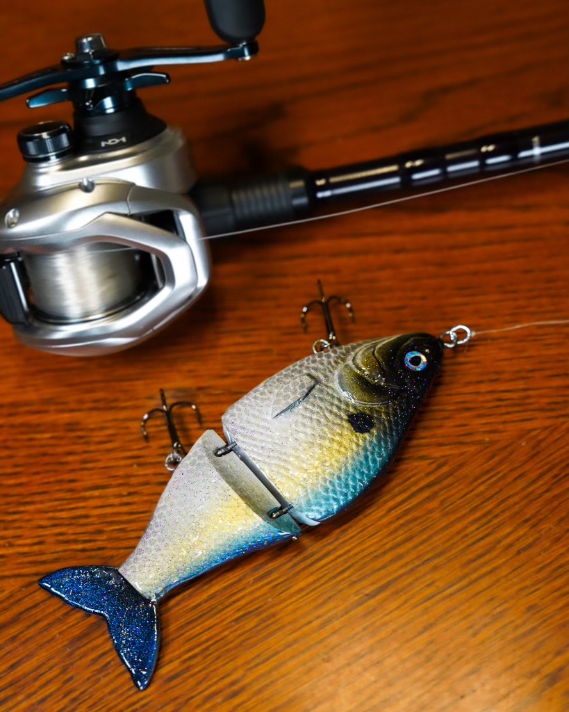 An image of the Sexy Shad by Bully Baits next to a fishing pole.